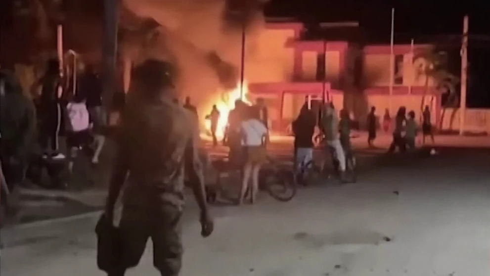 Cuban demonstrators observe the headquarters of the communist party in the burned town of Morón