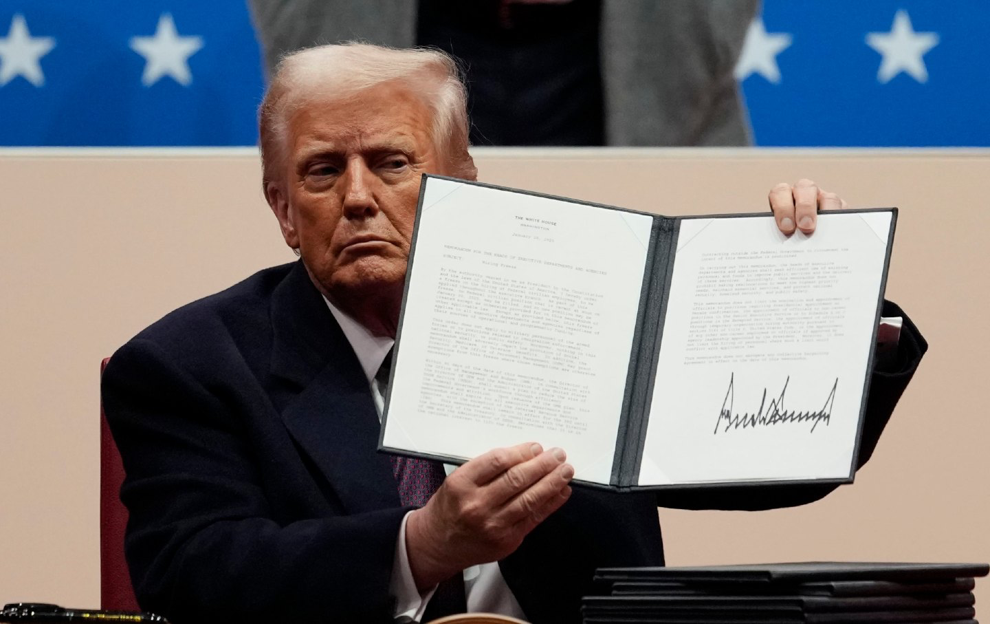 Trump signs the executive order.