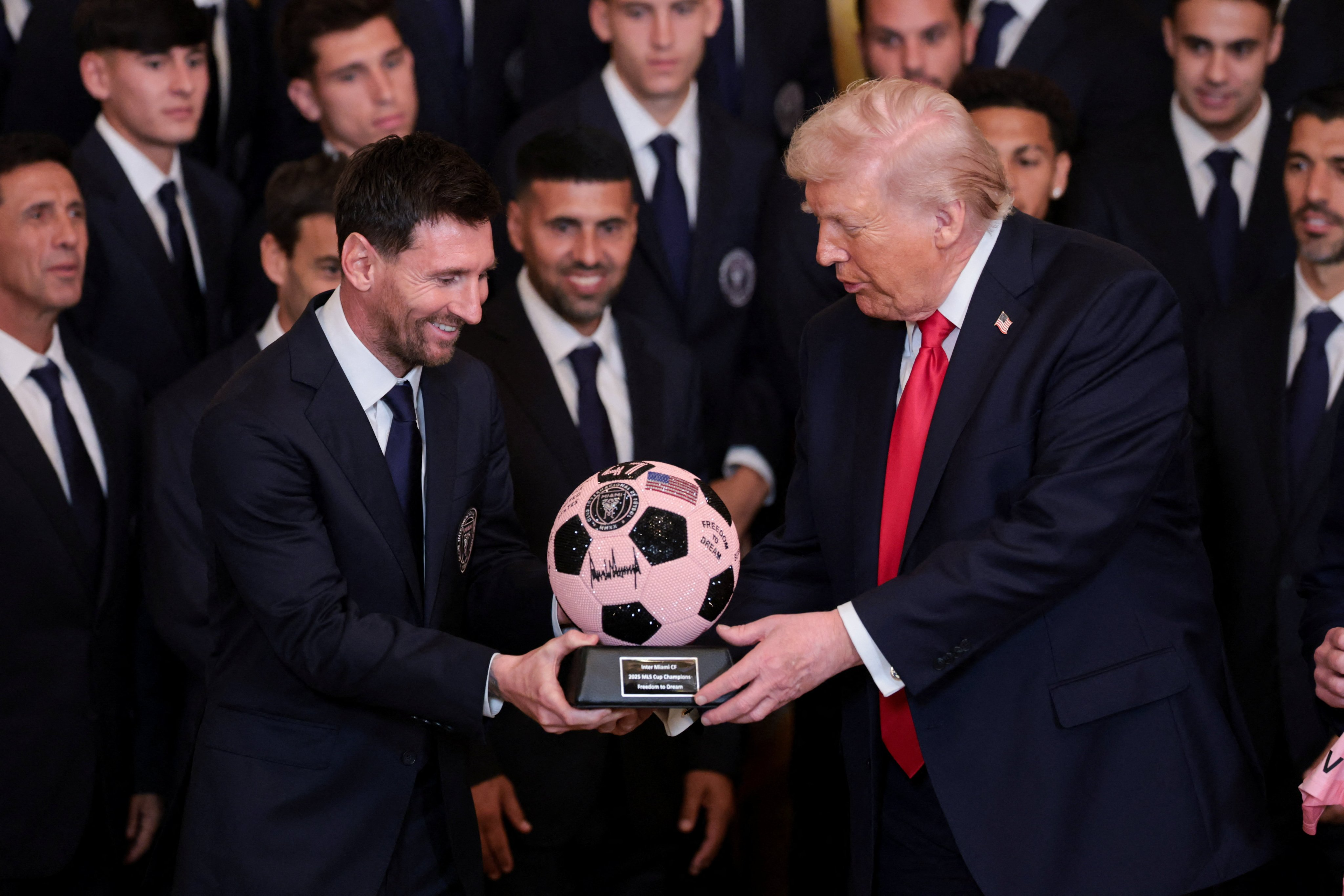 Messi handing him a pink ball signed by the entire squad