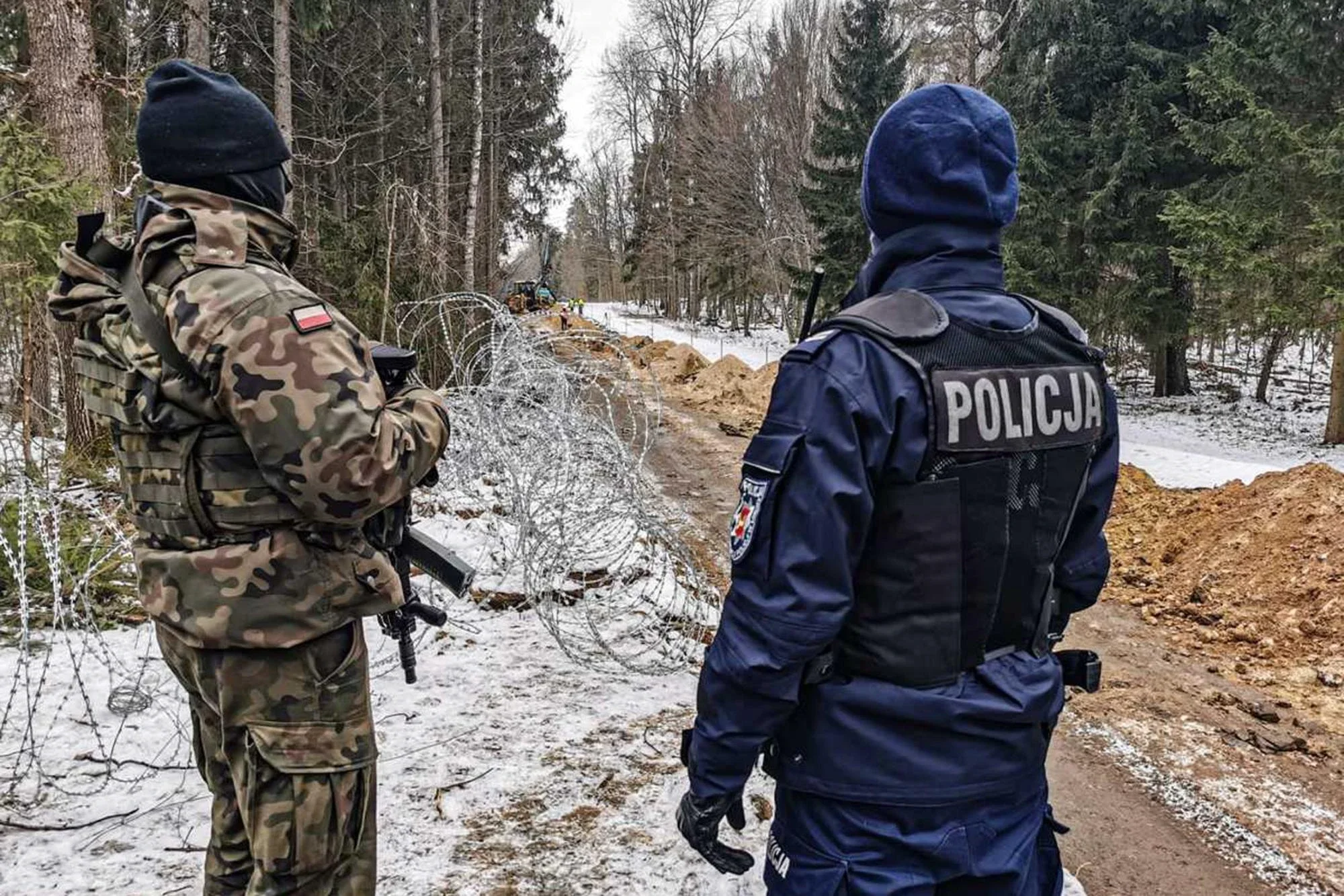 Un soldado y un policía de Polonia patrullando la frontera con Bielorrusia