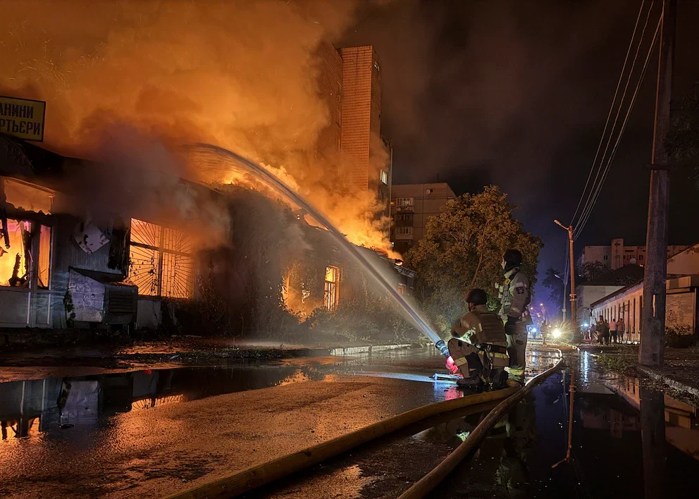 Bomberos ucranianos apagando el fuego causado por un bombardeo