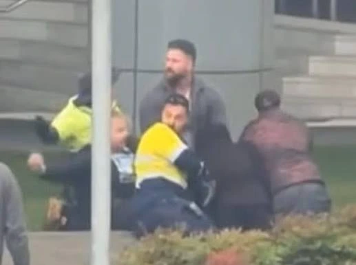 El inmigrante ilegal siendo detenido por la policía y por civiles  