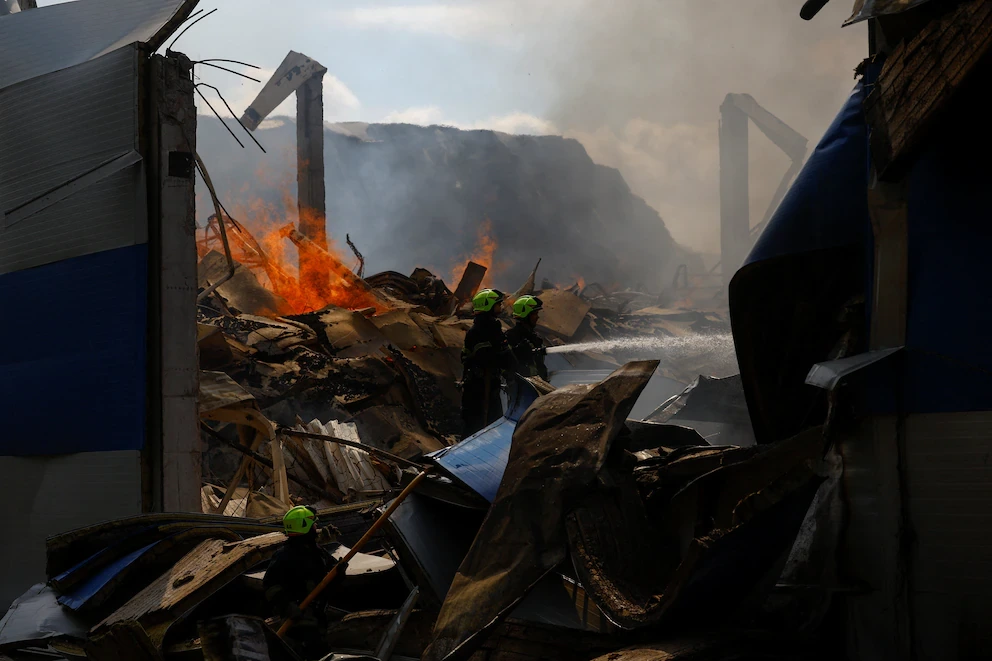 Bomberos ucranianos apagando el fuego causado por un bombardeo