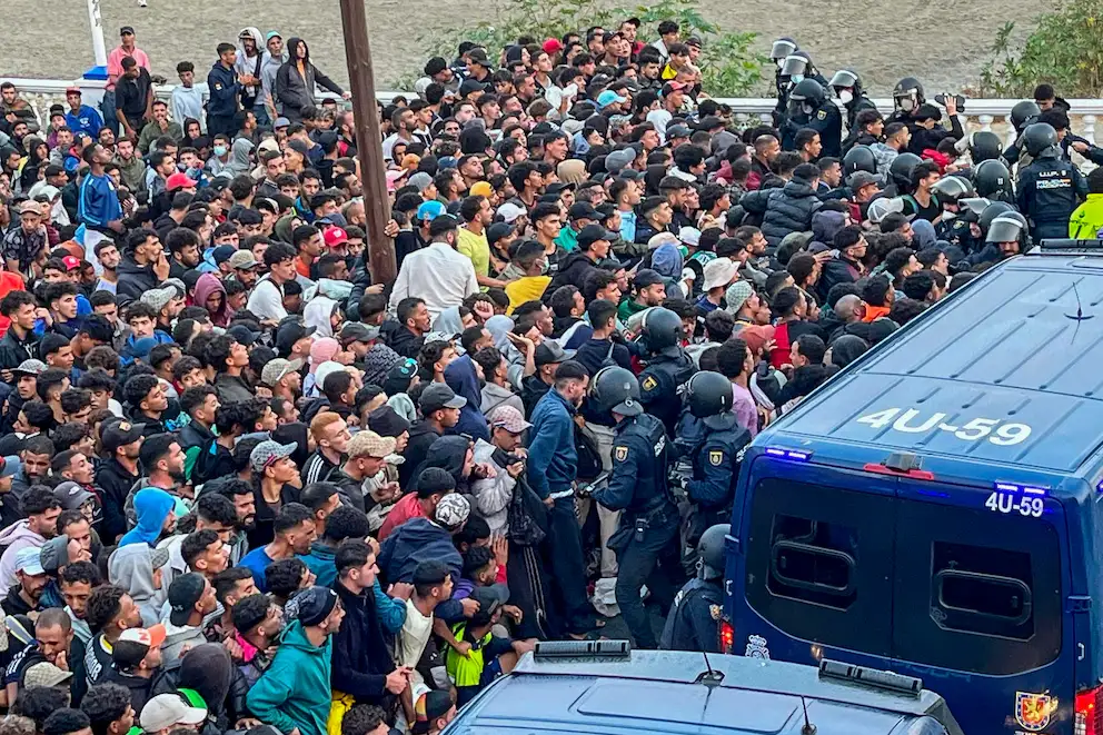 Inmigrantes ilegales siendo movidos por la policía en Ceuta
