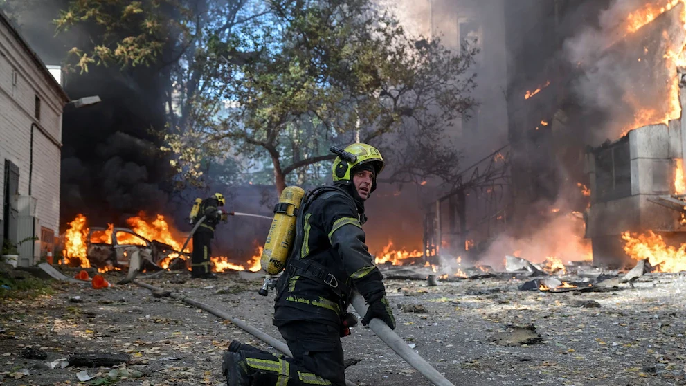 Bomberos ucranianos apagando el fuego causado por un bombardeo