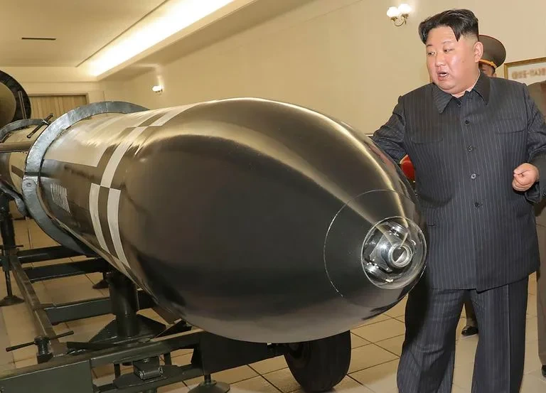 El dictador Kim Jong-un junta a una ojiva nuclear