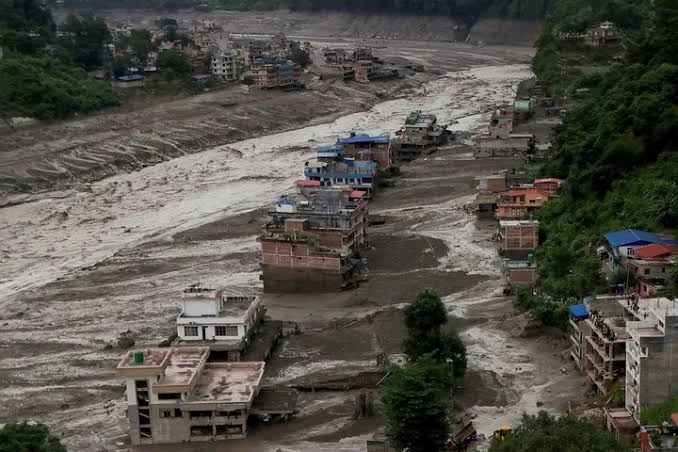 Why did the devastating floods between Nepal and Tibet occur, leaving at least 98 dead